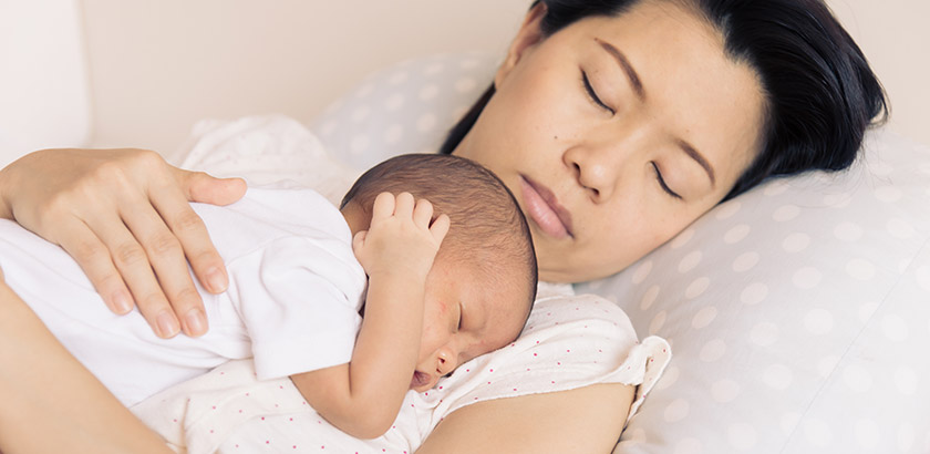 Sovende baby på mors bryst